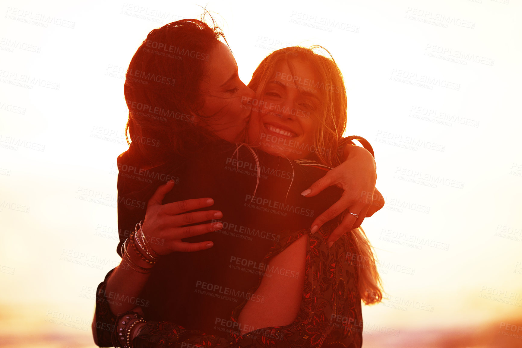 Buy stock photo Shot of two young women spending the day at the beach at sunset