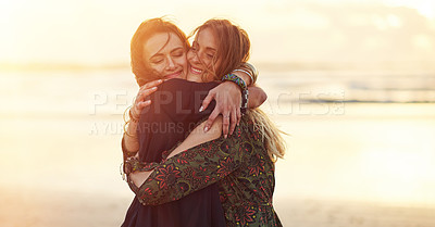 Buy stock photo Shot of two young women spending the day at the beach at sunset