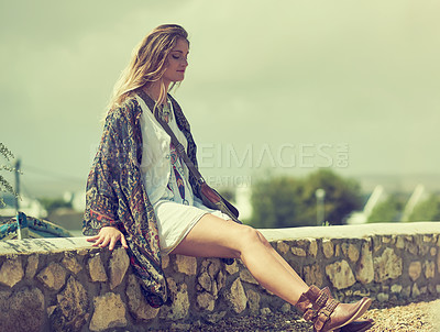 Buy stock photo Shot of a fashionable young woman posing outside on a sunny day