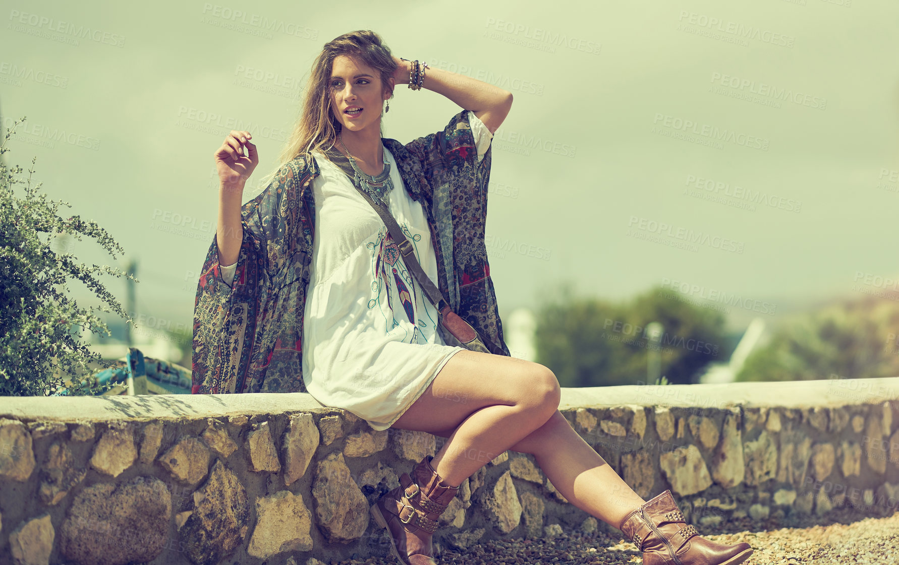 Buy stock photo Shot of a fashionable young woman posing outside on a sunny day