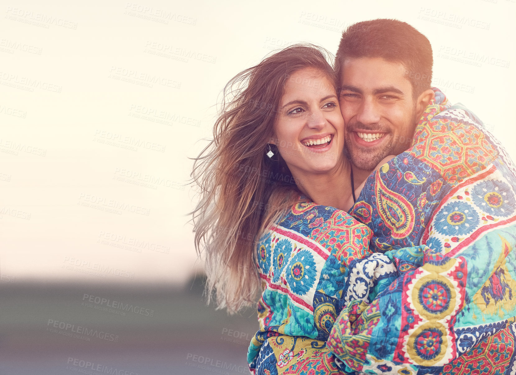 Buy stock photo Shot of an affectionate young couple at the beach