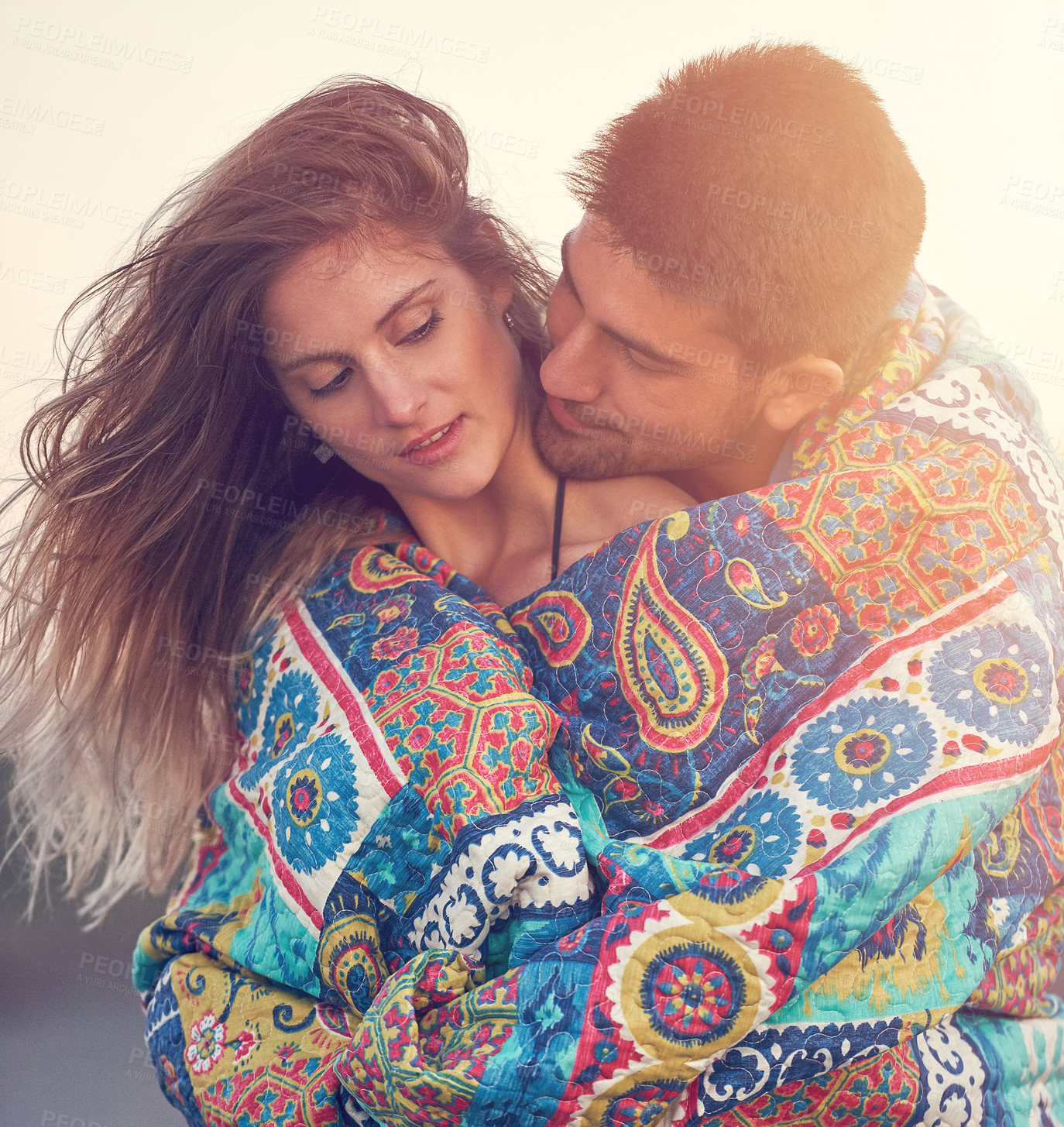 Buy stock photo Shot of an affectionate young couple at the beach