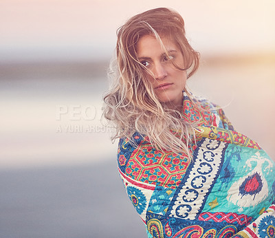 Buy stock photo Cropped shot of an attractive young woman wrapped in a blanket on the beach