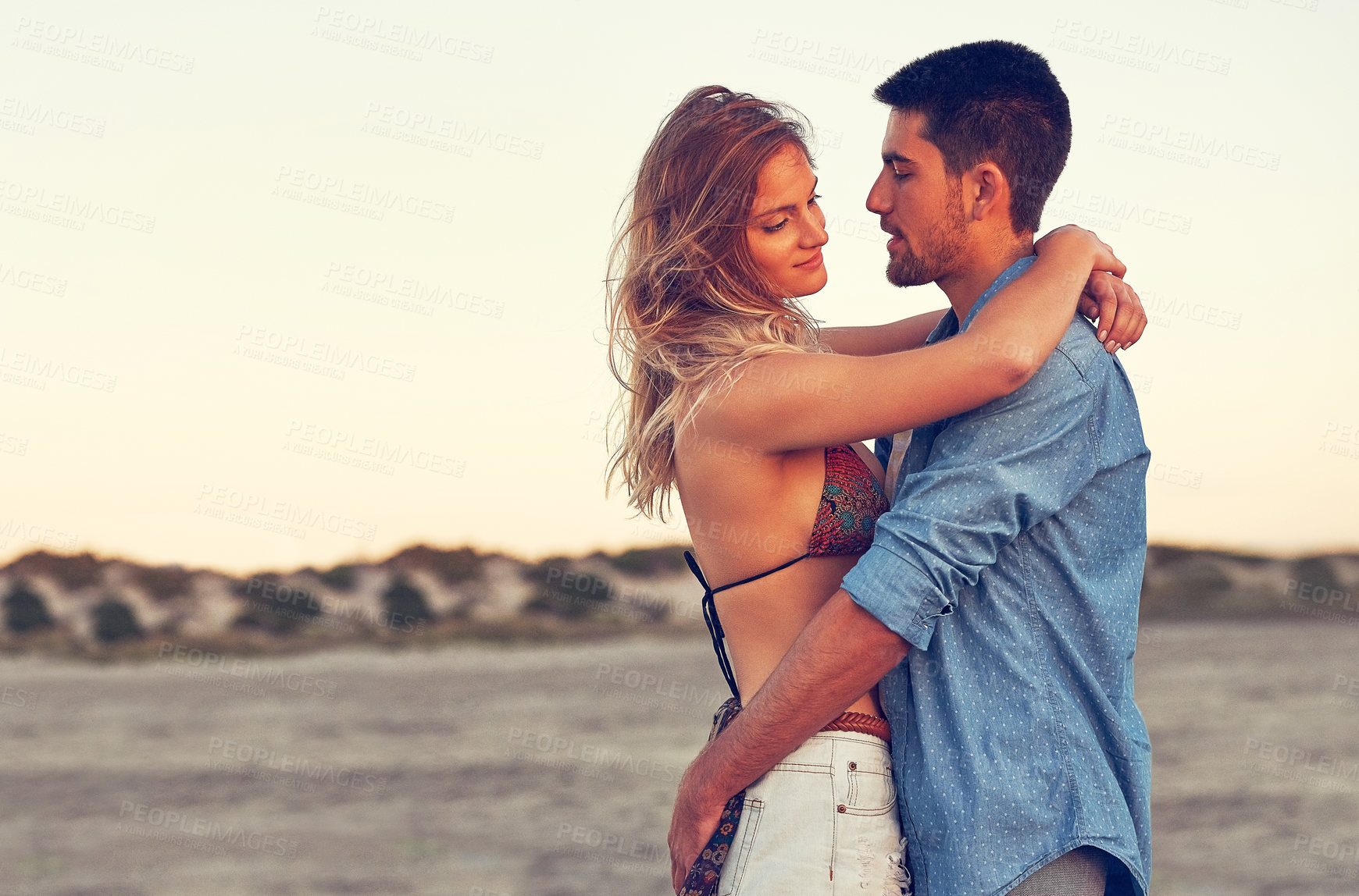 Buy stock photo Shot of an affectionate young couple at the beach