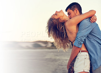 Buy stock photo Shot of an affectionate young couple at the beach