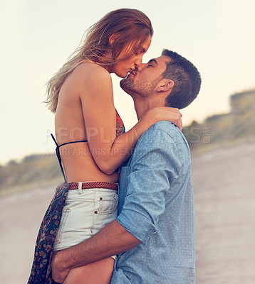 Buy stock photo Shot of an affectionate young couple at the beach