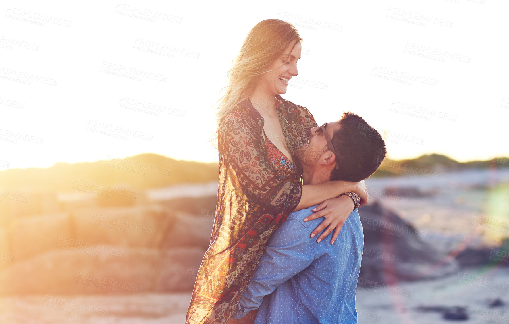 Buy stock photo Shot of an affectionate young couple at the beach