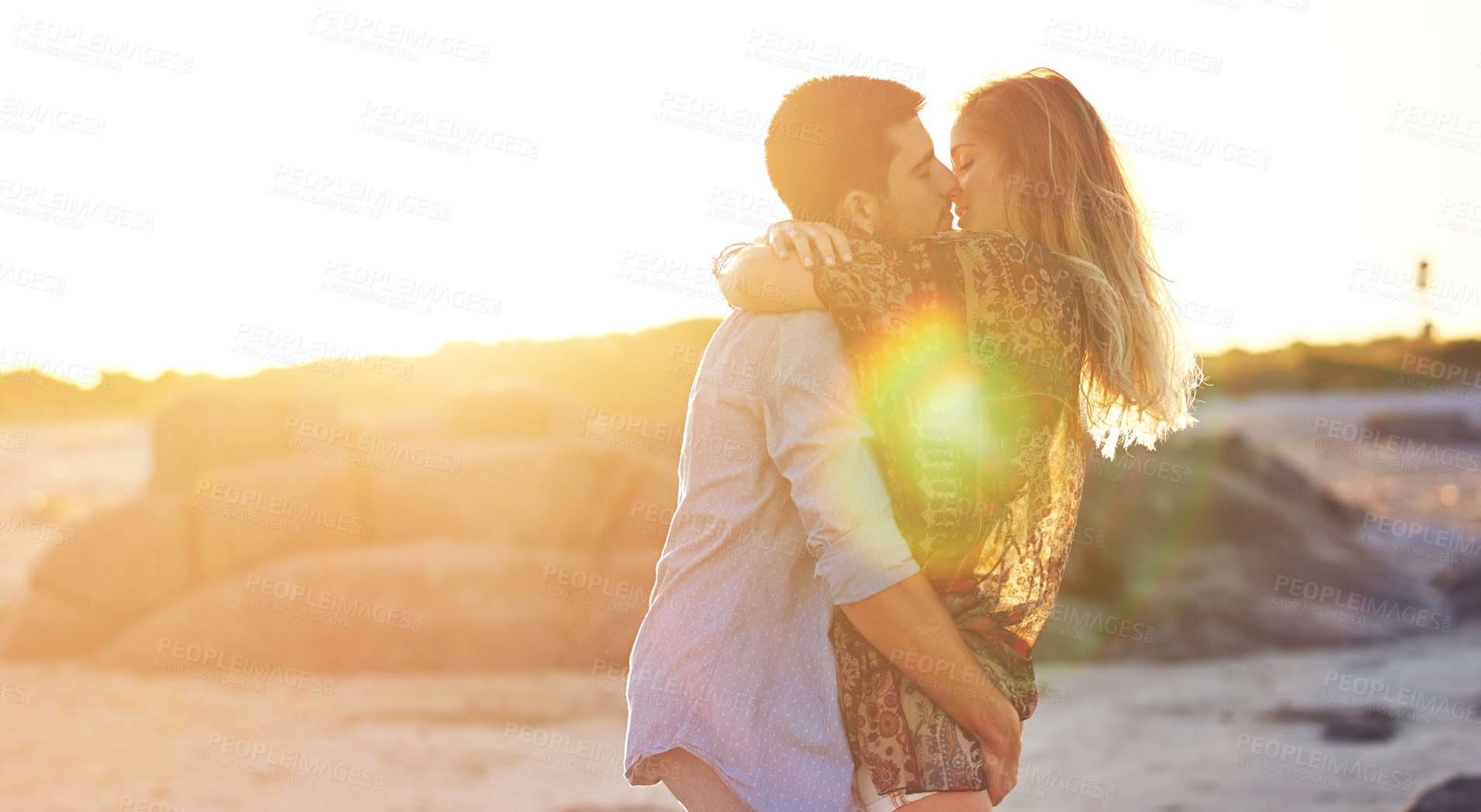 Buy stock photo Shot of an affectionate young couple at the beach