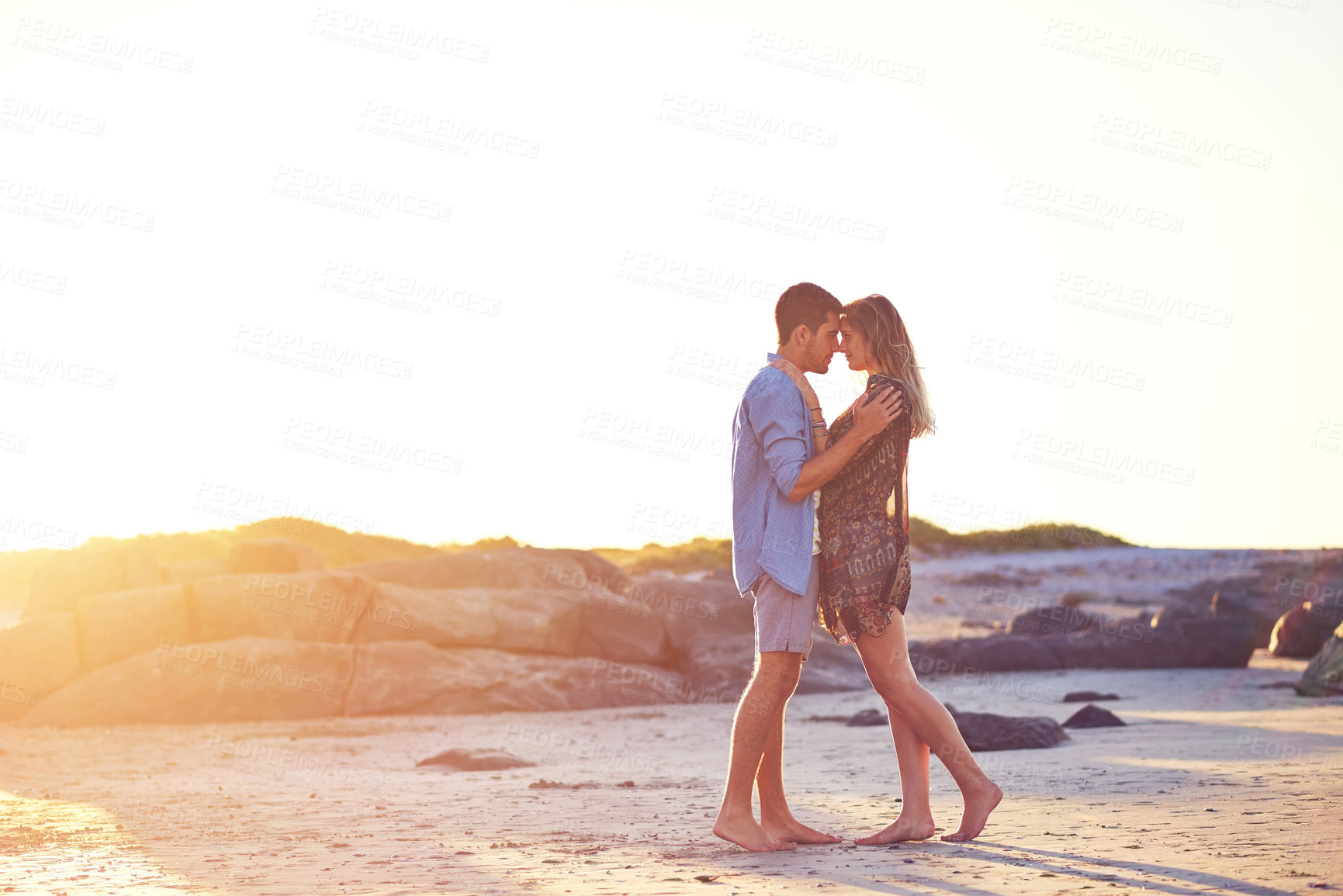 Buy stock photo Shot of an affectionate young couple at the beach