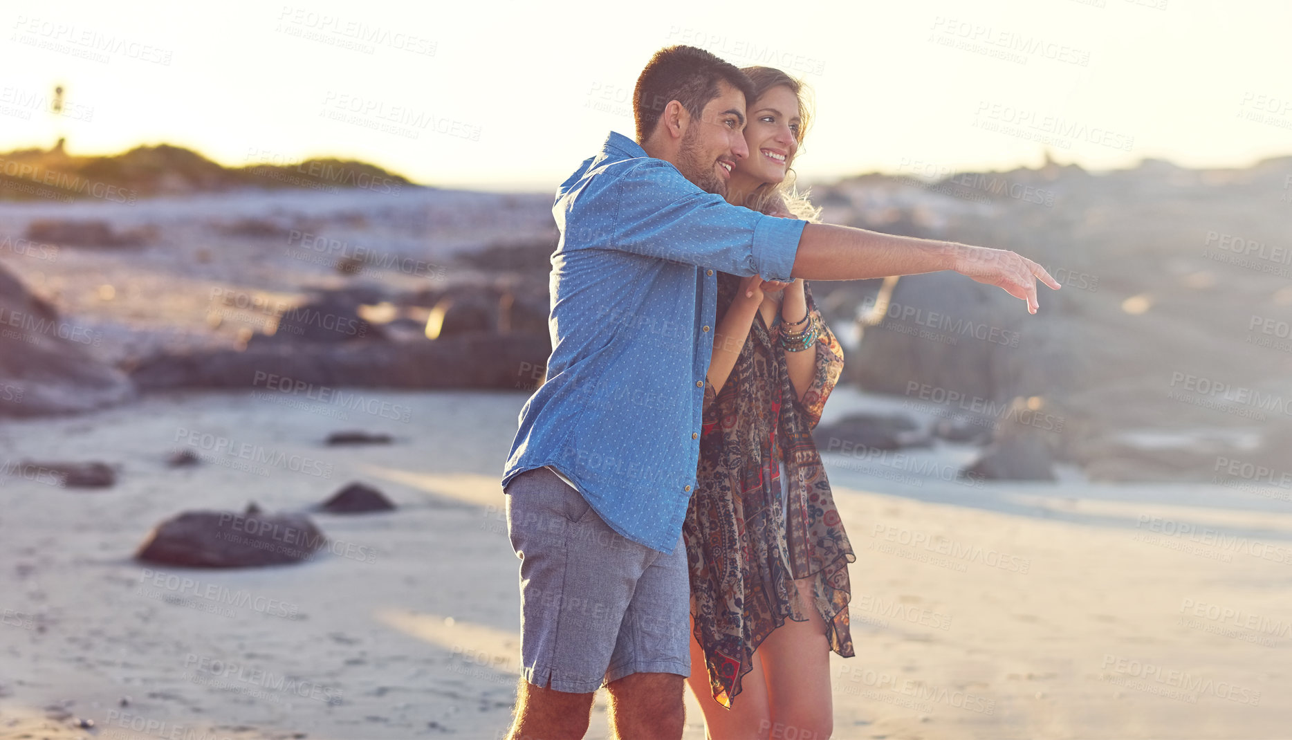 Buy stock photo Shot of a happy young couple going for a walk along the beach