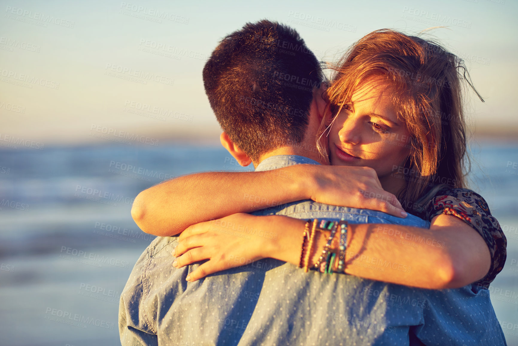 Buy stock photo Shot of an affectionate young couple at the beach