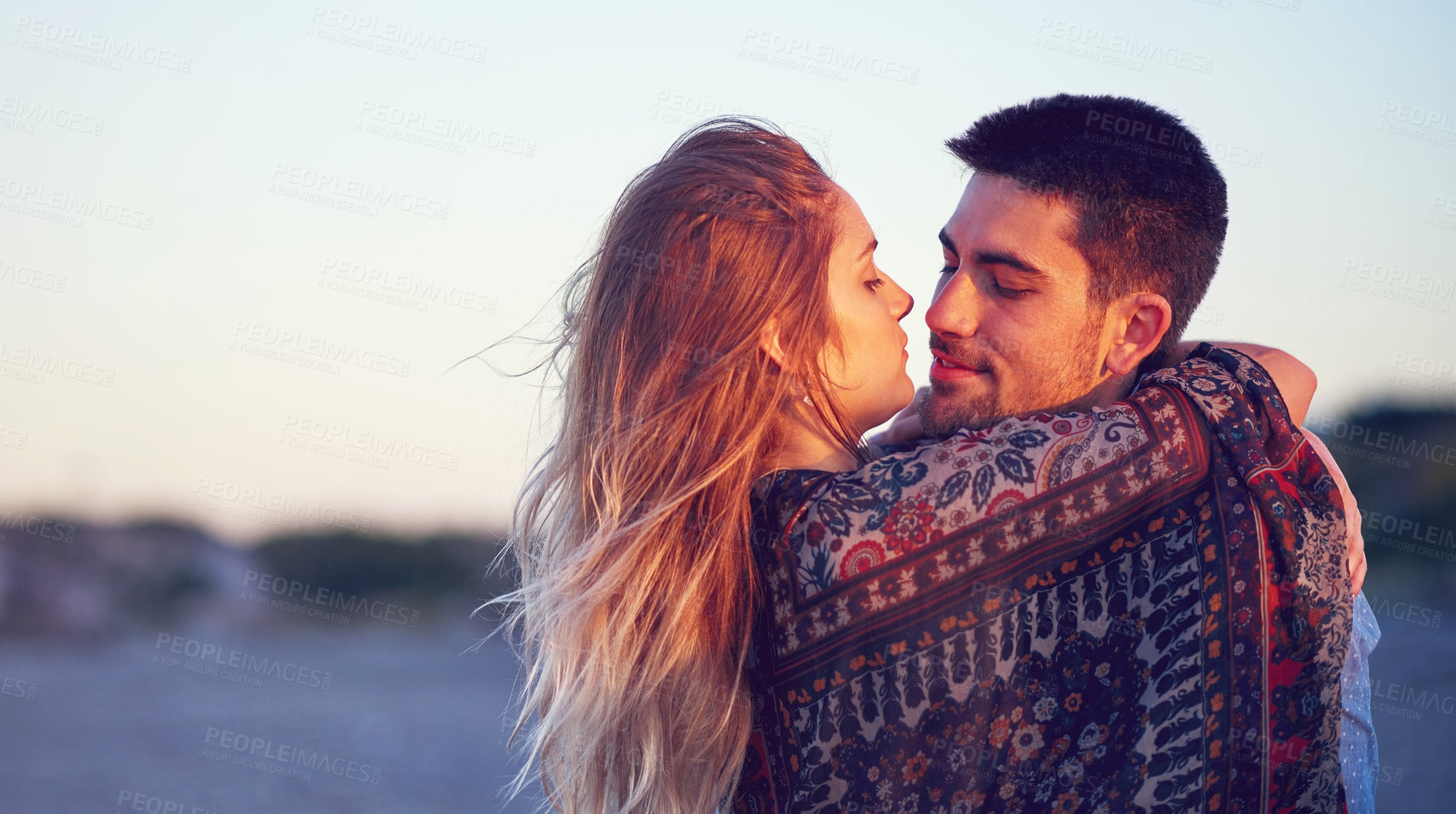 Buy stock photo Shot of an affectionate young couple at the beach