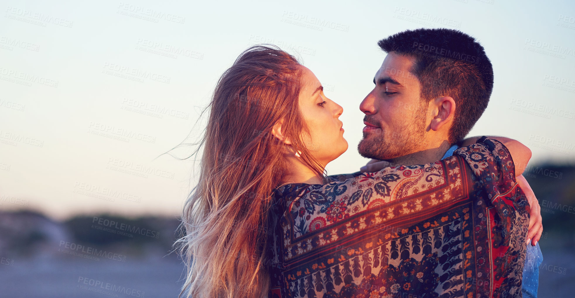 Buy stock photo Shot of an affectionate young couple at the beach