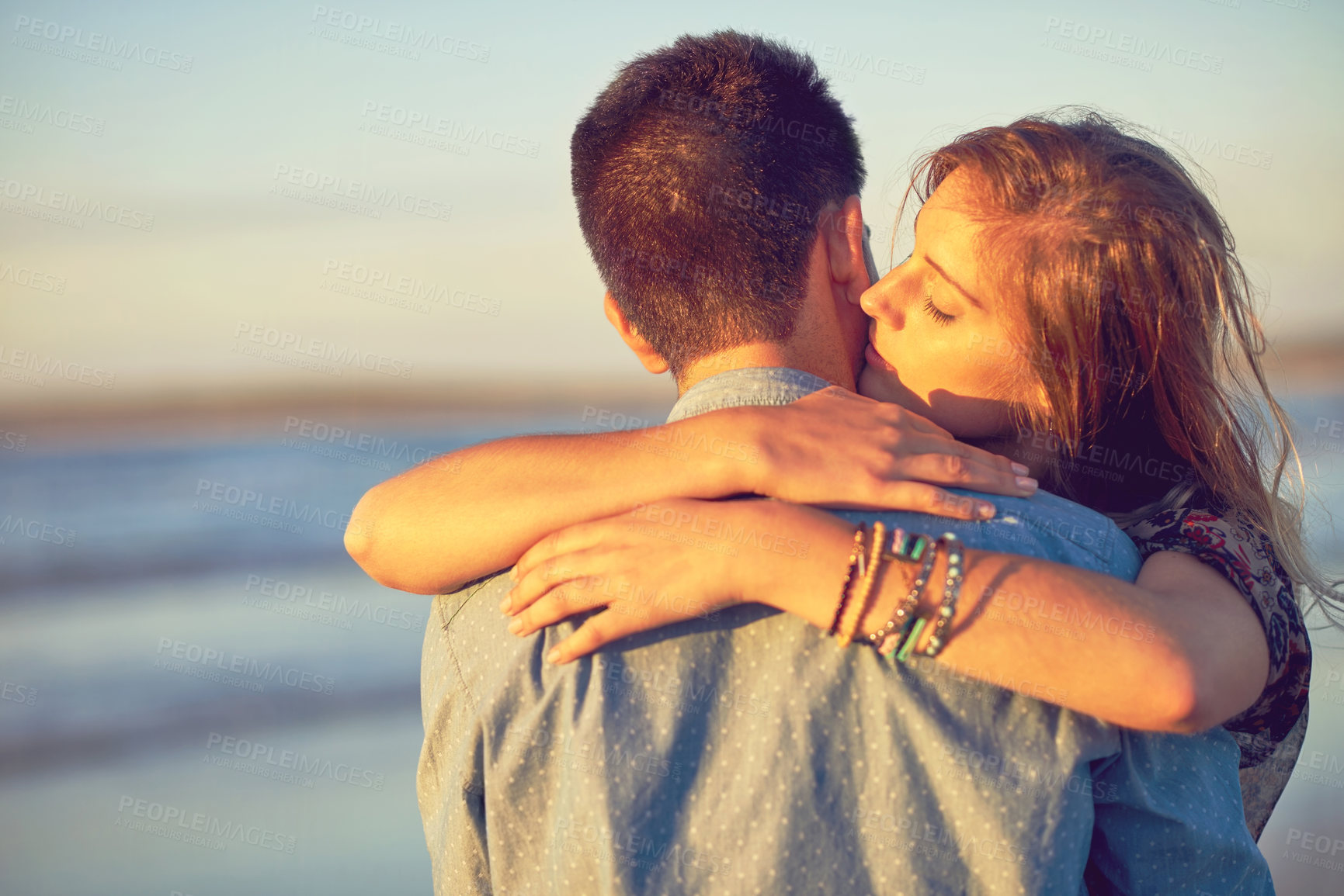 Buy stock photo Shot of an affectionate young couple at the beach