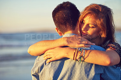 Buy stock photo Shot of an affectionate young couple at the beach