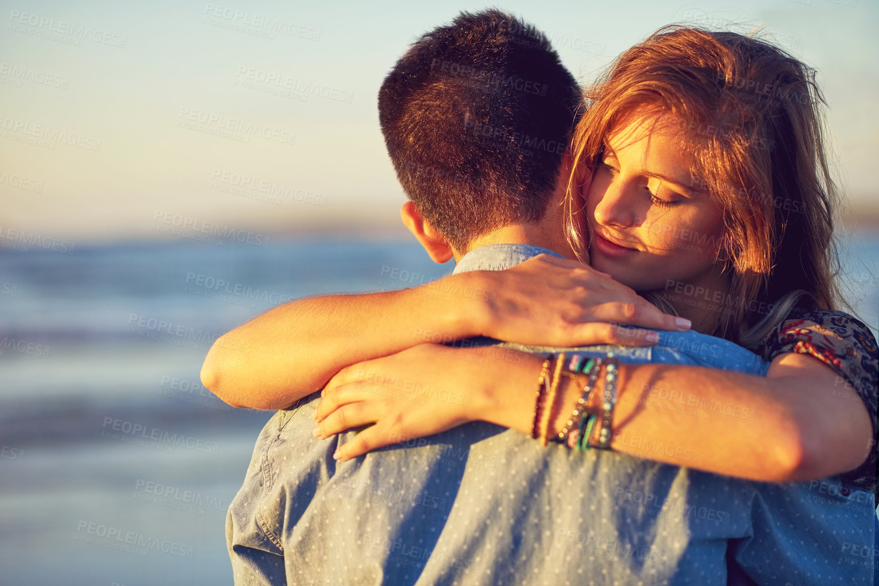 Buy stock photo Shot of an affectionate young couple at the beach