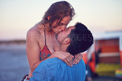Buy stock photo Kiss, love and couple at the beach on date, vacation or road trip in summer at sunset, together and romantic adventure. People, dating and support in relationship, happiness or boyfriend and girl