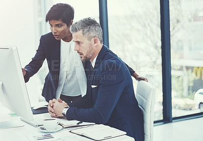 Buy stock photo Shot of a businesswoman and businessman using a computer together at work