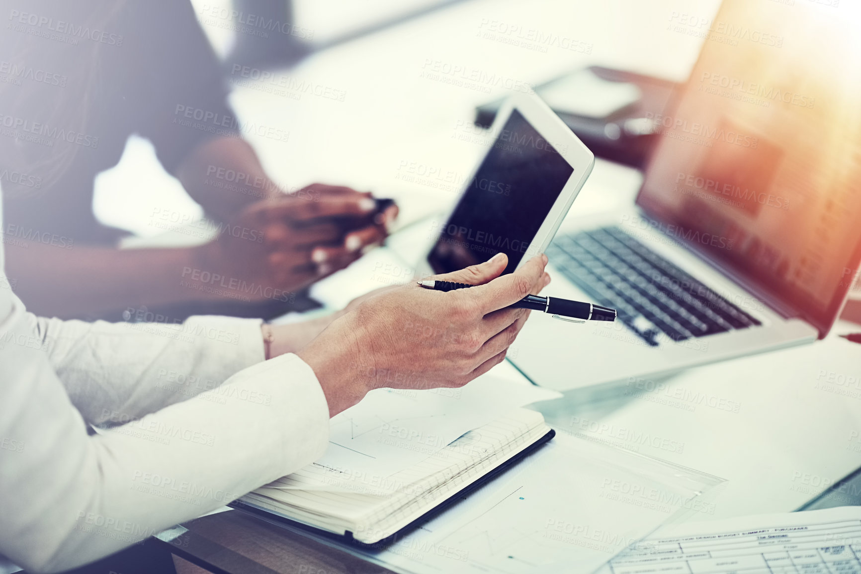 Buy stock photo Cropped shot of two colleagues using a digital tablet together during a collaboration at work