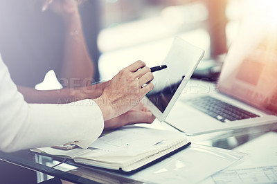 Buy stock photo Cropped shot of two colleagues using a digital tablet together during a collaboration at work