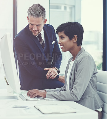Buy stock photo Shot of a businesswoman and businessman using a computer together at work