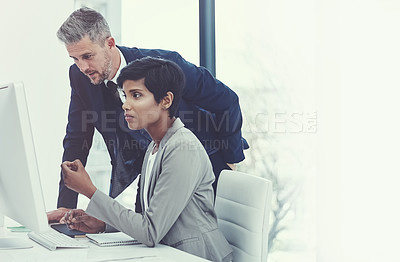 Buy stock photo Shot of a businesswoman and businessman using a computer together at work