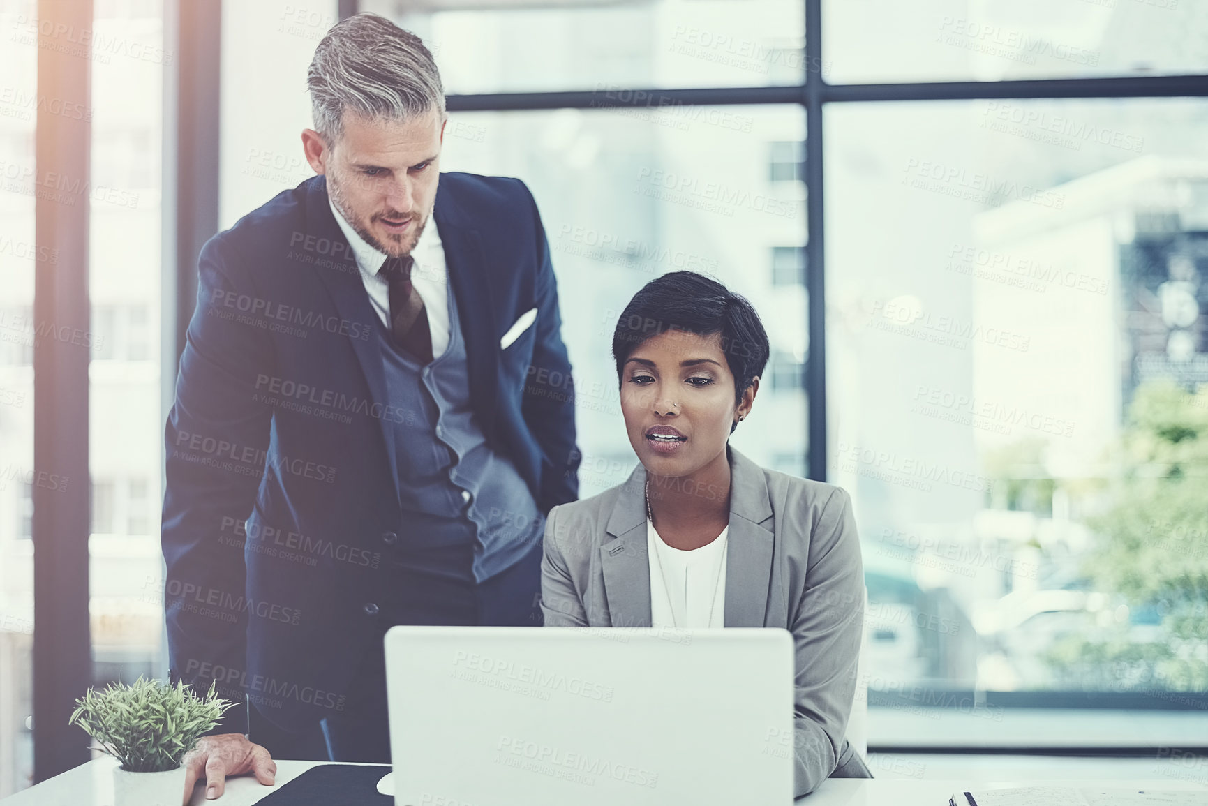 Buy stock photo Shot of a businesswoman and businessman using a laptop together at work