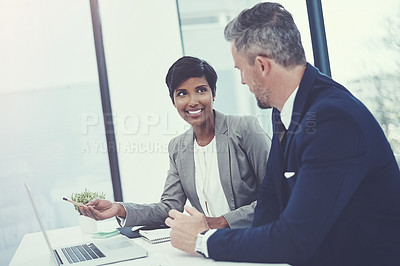 Buy stock photo Shot of a businesswoman and businessman using a laptop together at work