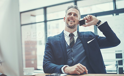 Buy stock photo Shot of a mature businessman using a cellphone at his desk in a modern office