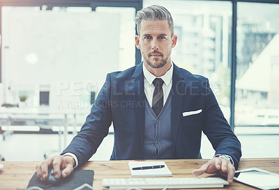 Buy stock photo Portrait of a mature businessman using a computer at his desk in a modern office