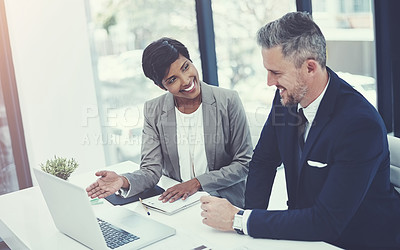 Buy stock photo Shot of a businesswoman and businessman using a laptop together at work