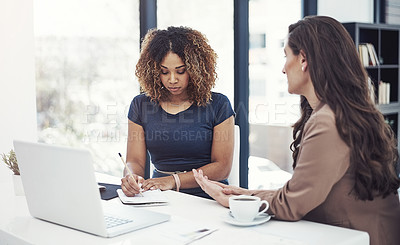 Buy stock photo Shot of two businesswomen collaborating on a project at work