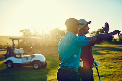 Buy stock photo Shot of two friends playing a round of golf out on a golf course