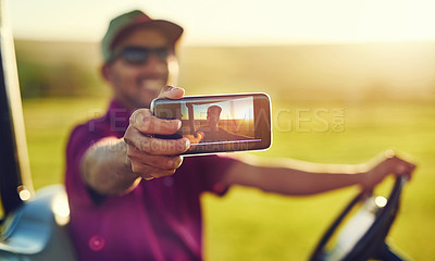 Buy stock photo Shot of a young man taking a selfie on a golf course