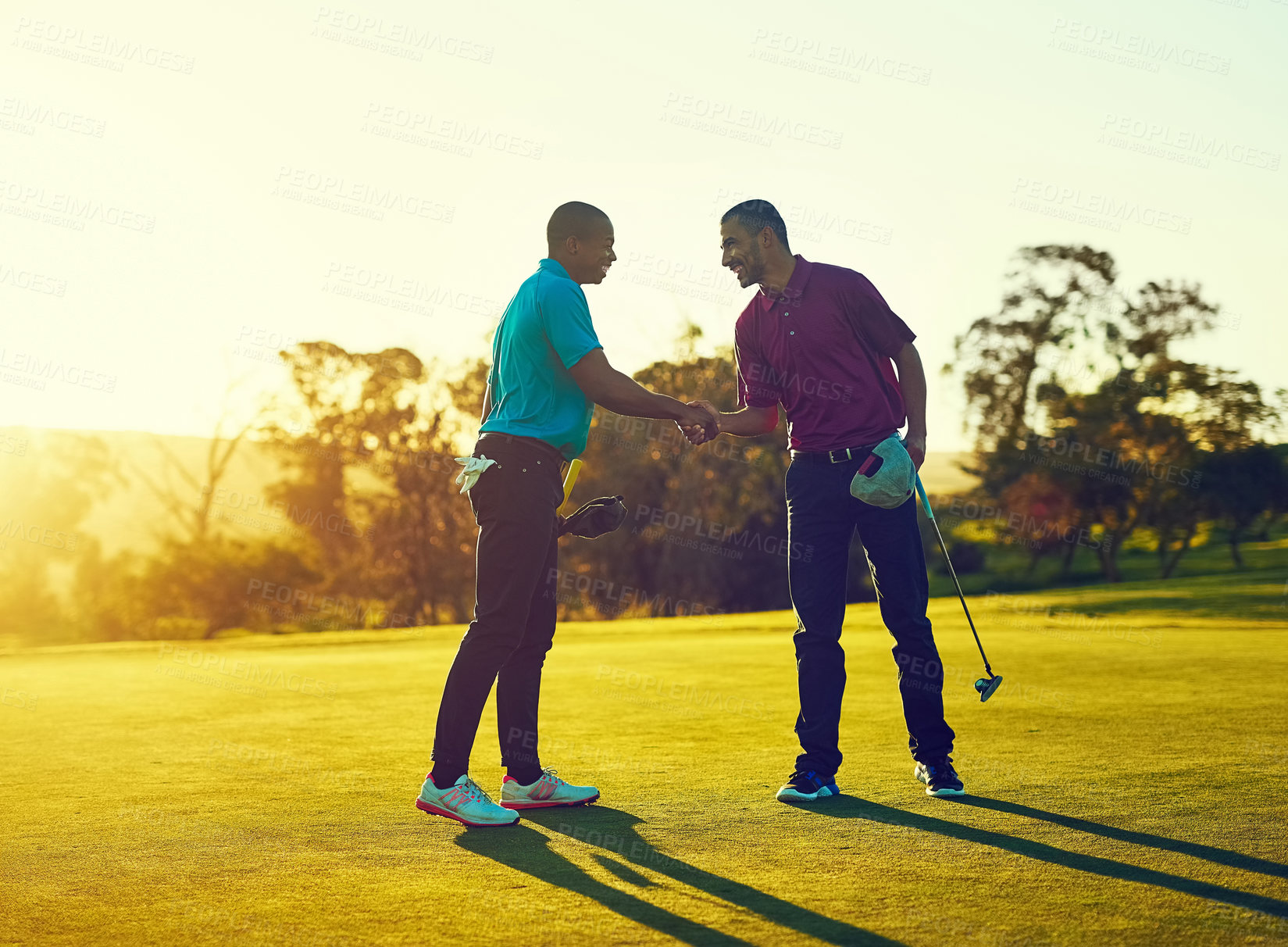 Buy stock photo Shot of two golfers shaking hands on the golf course