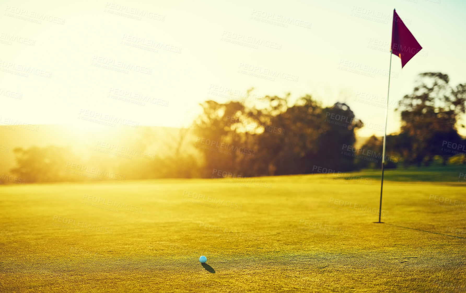 Buy stock photo Shot of a golf ball and flag on an empty course