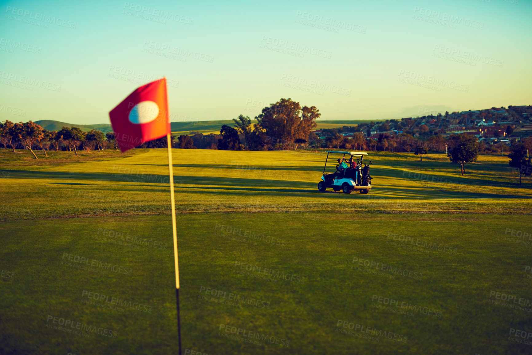 Buy stock photo Shot of two golfers riding in a cart on a golf course