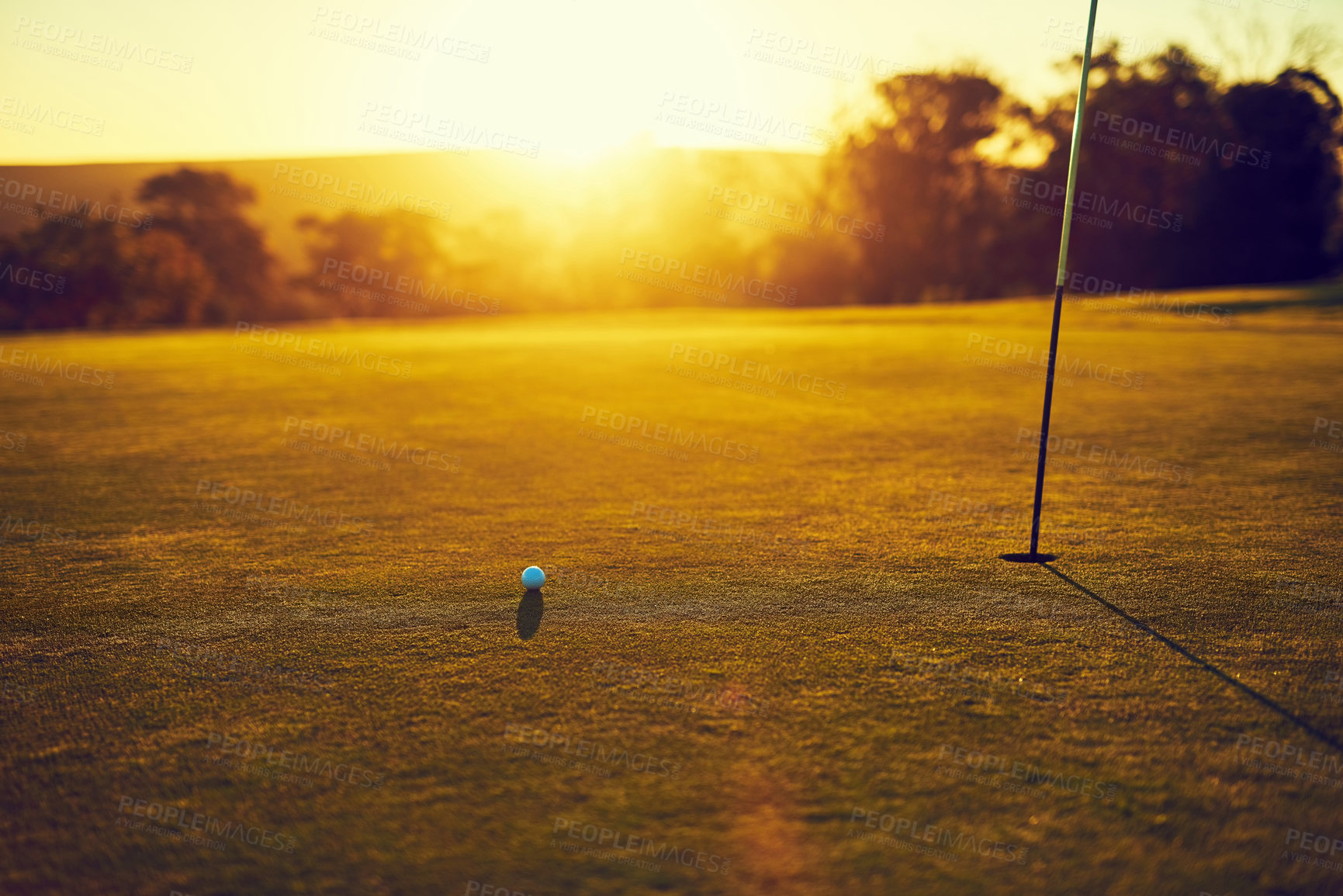 Buy stock photo Shot of a golf ball and flag on an empty course