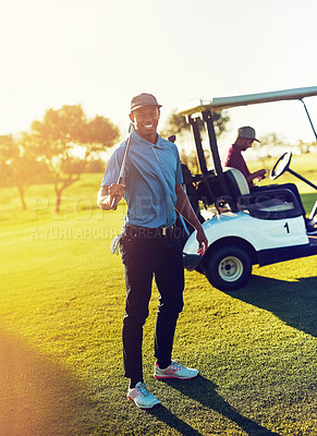 Buy stock photo Shot of a golfer holding his club with a buggy blurred in the background