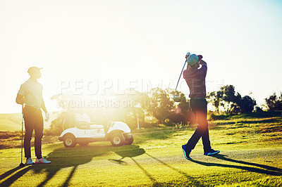 Buy stock photo Shot of two friends playing a round of golf out on a golf course