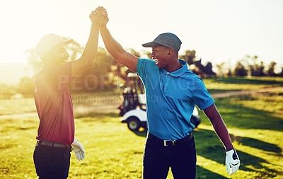 Buy stock photo Shot of two golfers high-fiving on a golf course