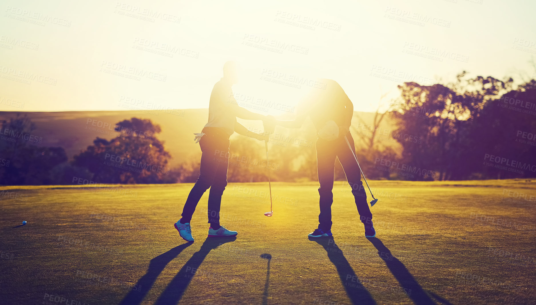 Buy stock photo Shot of two golfers shaking hands on the golf course