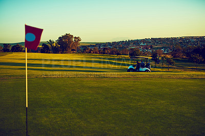 Buy stock photo Shot of two golfers riding in a cart on a golf course