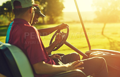 Buy stock photo Shot of two men sitting in a cart on a golf course