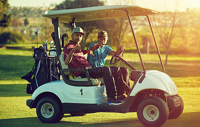 Buy stock photo Shot of two golfers riding in a cart on a golf course