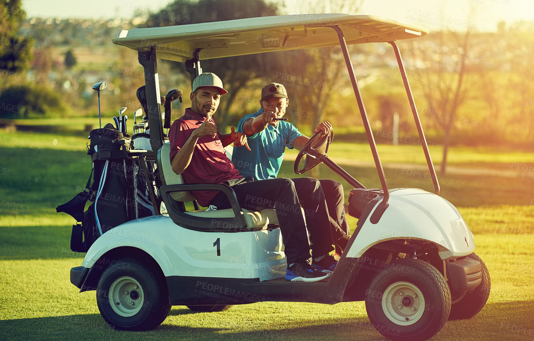 Buy stock photo Shot of two golfers riding in a cart on a golf course