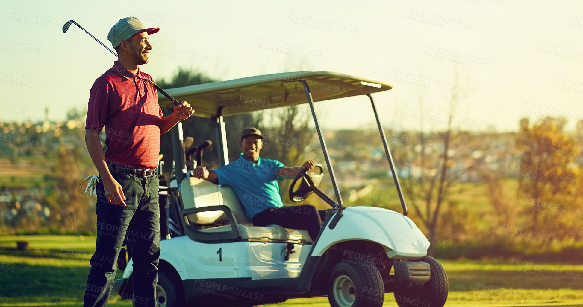 Buy stock photo Shot of a golfer holding his club with a buggy blurred in the background