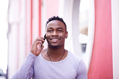 Buy stock photo Shot of a young man using his phone outdoors