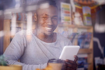 Buy stock photo Cropped shot of a handsome young man using his tablet while sitting in a cafe