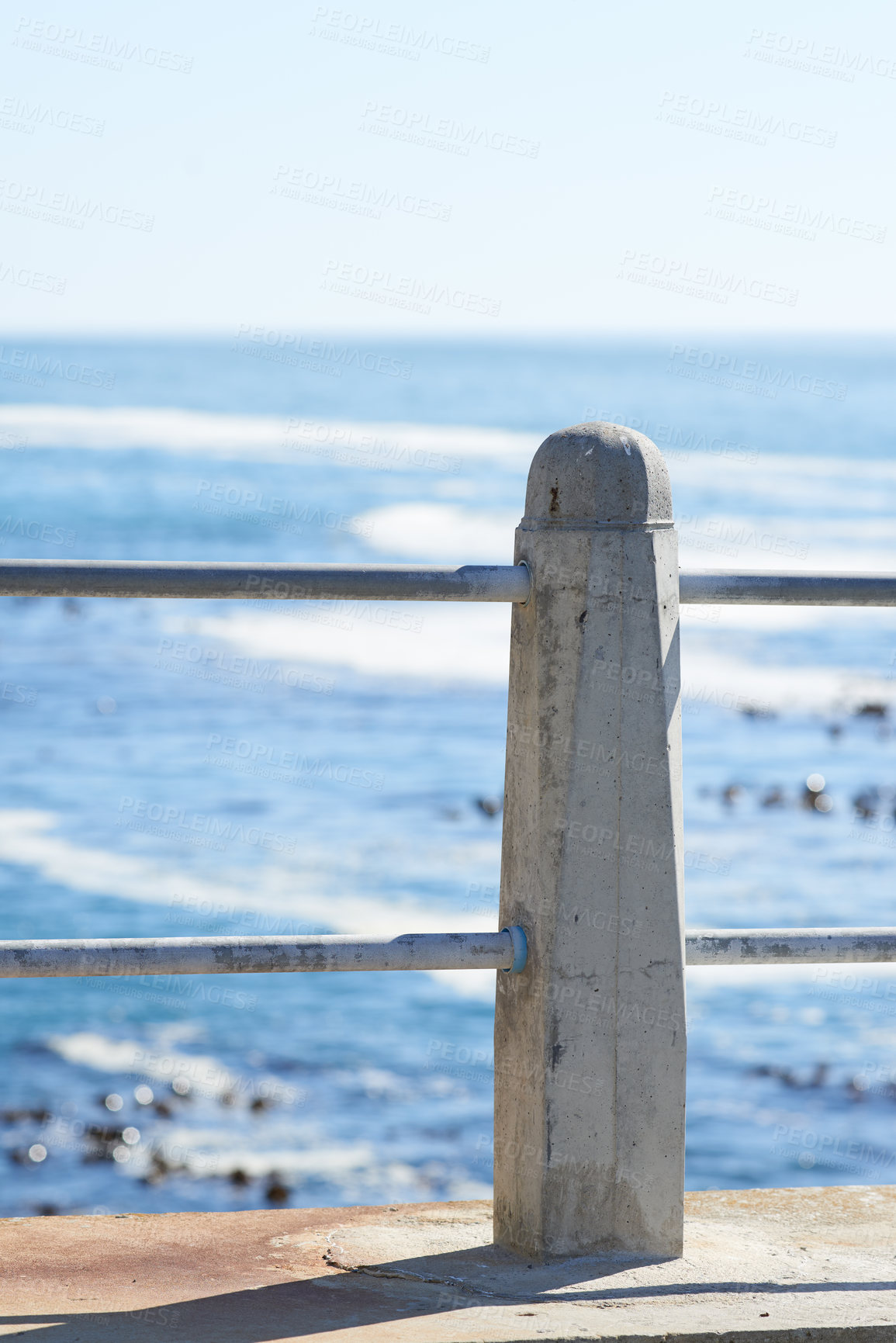 Buy stock photo Outdoor, holiday and beach with promenade, railing and destination for travel getaway at sea. Island tourism, nature and ocean with pole or natural waves for paradise or vacation adventure in Greece